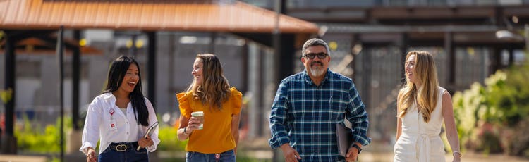 Four employees walking outside