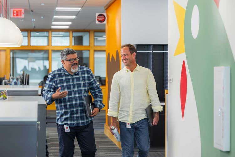 Two employees walking down hallway
